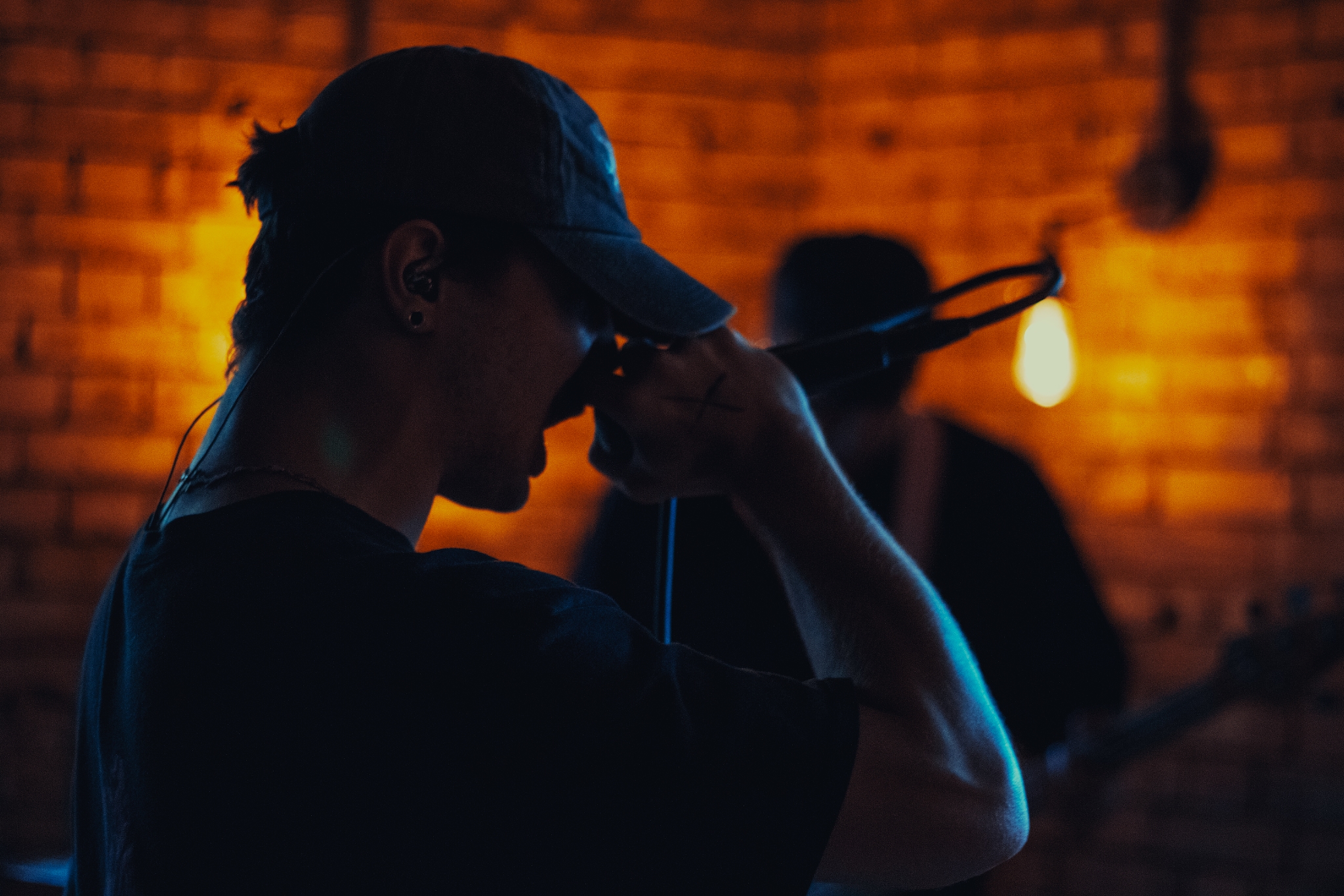Photograph of a person screaming into a microphone.